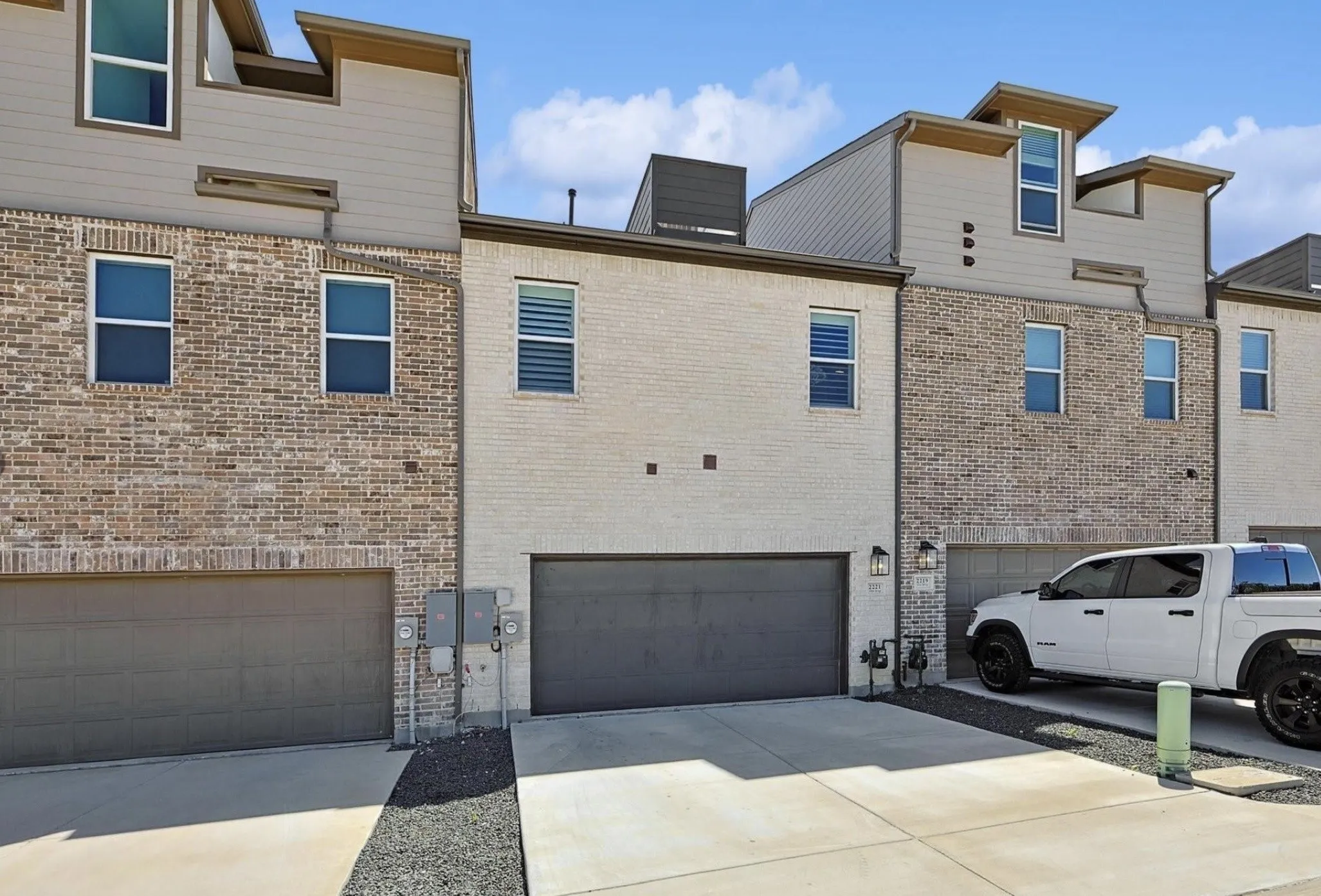Modern multi-story facade featuring brick and siding finishes