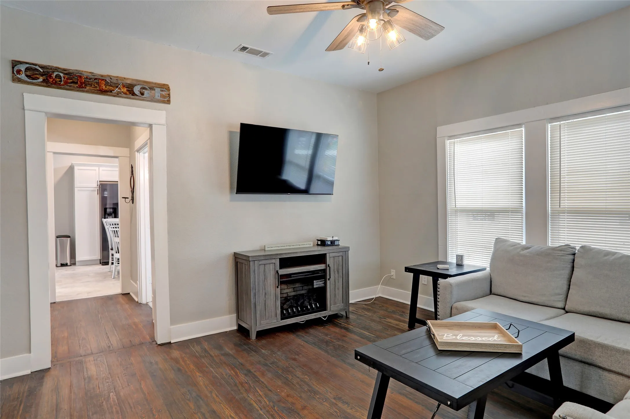 Wood-finish flooring throughout, ceiling fan with integrated lighting, recessed lighting, and white trimmed windows