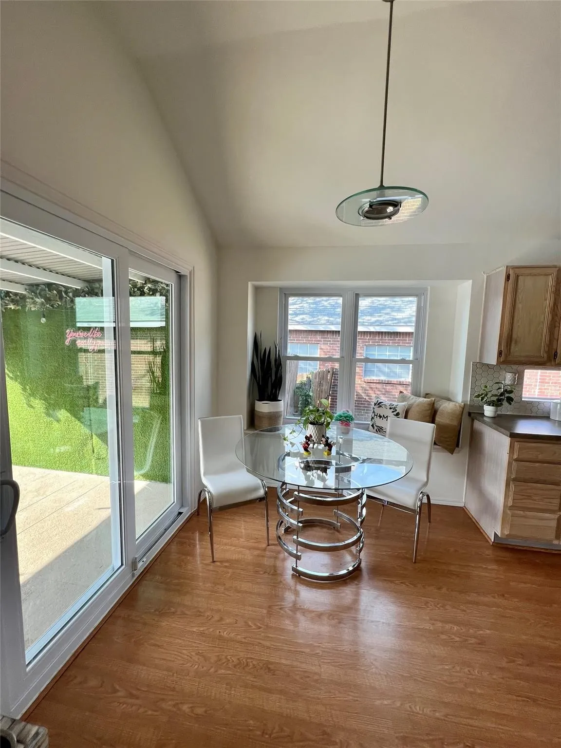 Wood-finish flooring throughout, vaulted ceiling, and sliding glass patio doors