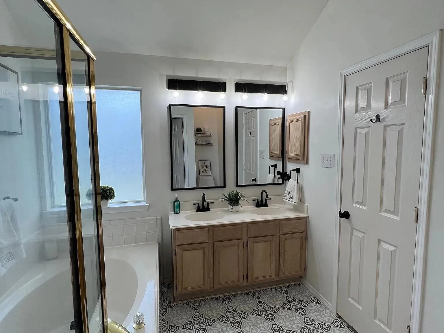 Dual vanity with integrated sinks, black fixtures, and framed mirrors