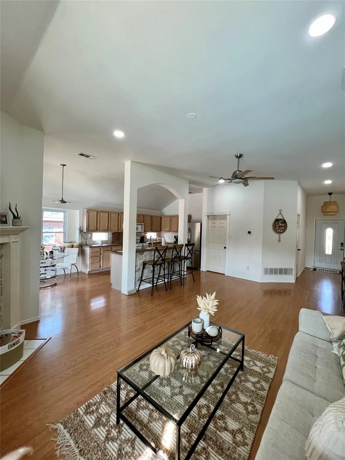 Open-concept living area with wood-finish flooring, recessed lighting, and a ceiling fan