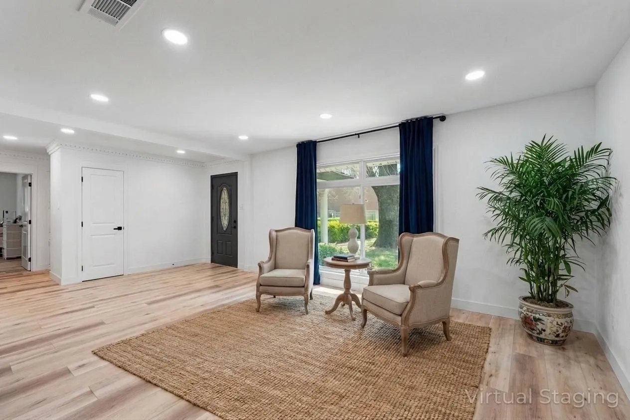 Recessed lighting, light wood-finish flooring, white walls, and a large window with white trim