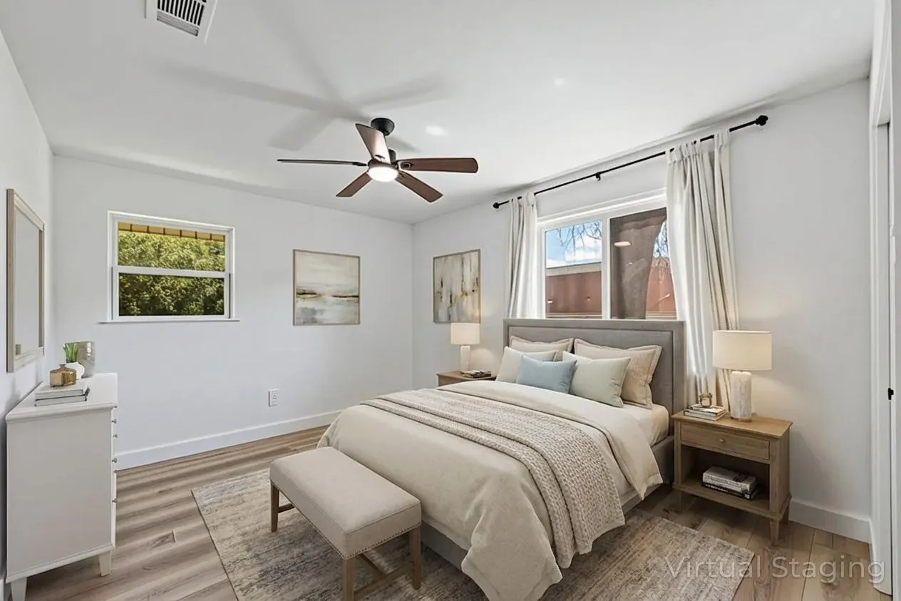 Wood-finish flooring, white walls, two windows, and a ceiling fan with integrated lighting