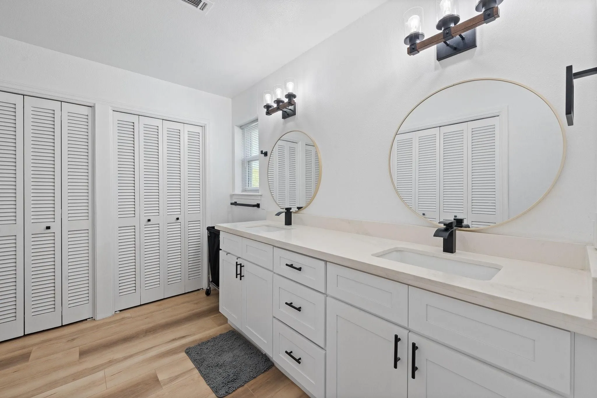 Dual vanity with integrated rectangular sinks, light-toned countertop, and matte black fixtures