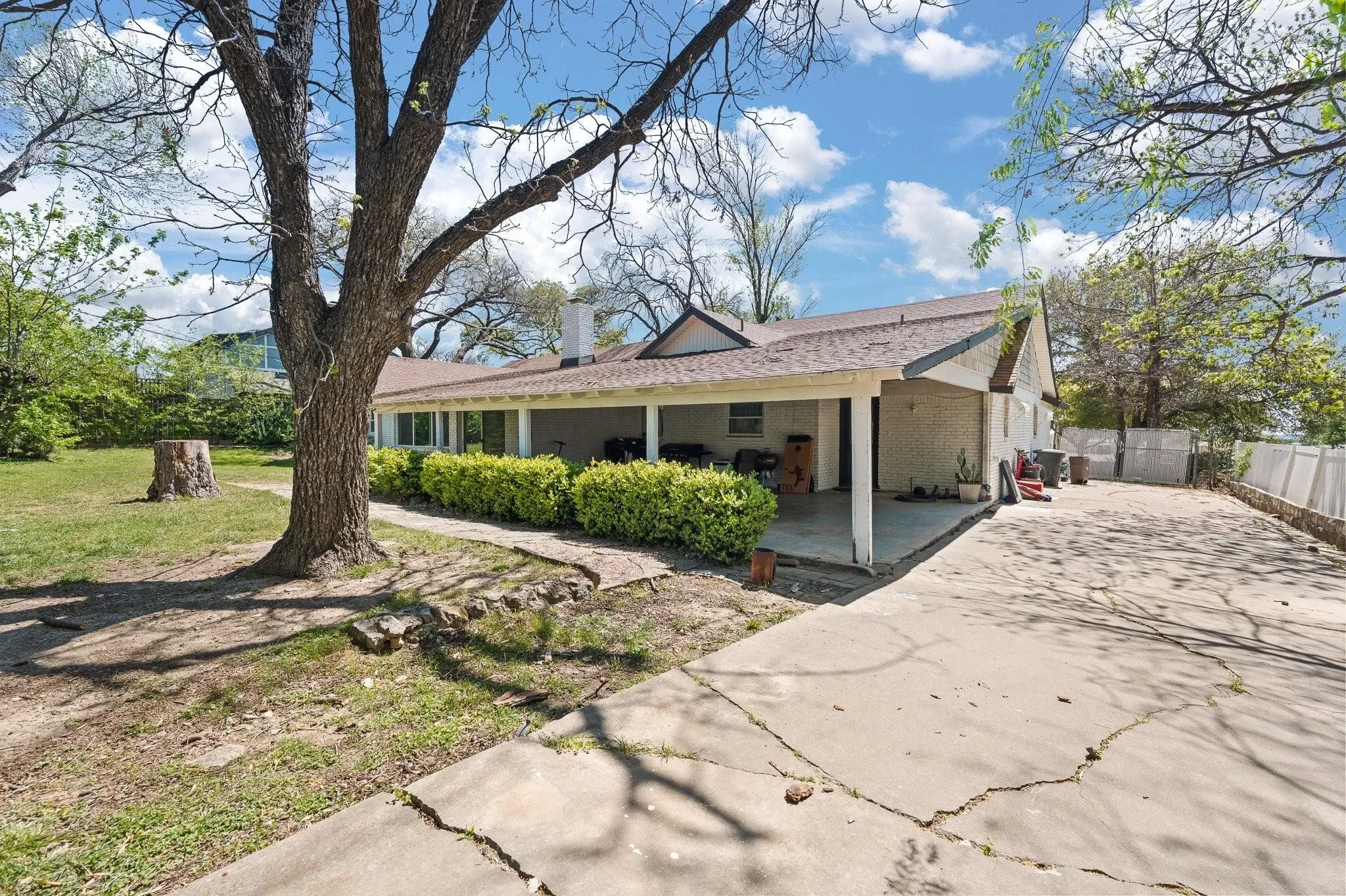 Charming single-story home with a covered front porch, situated on a spacious lot anchored by a mature shade tree