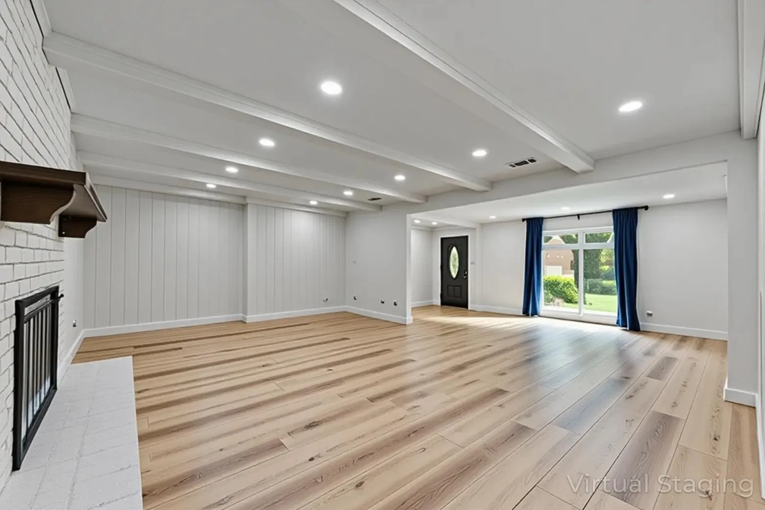 Spacious interior featuring wood-finish flooring, a white brick fireplace, exposed ceiling beams, and recessed lighting