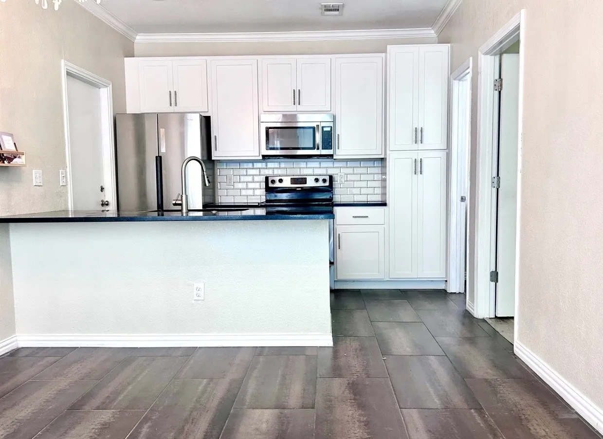 The kitchen features updates such as granite counter tops, tile backsplash, island and built-in pantry storage.