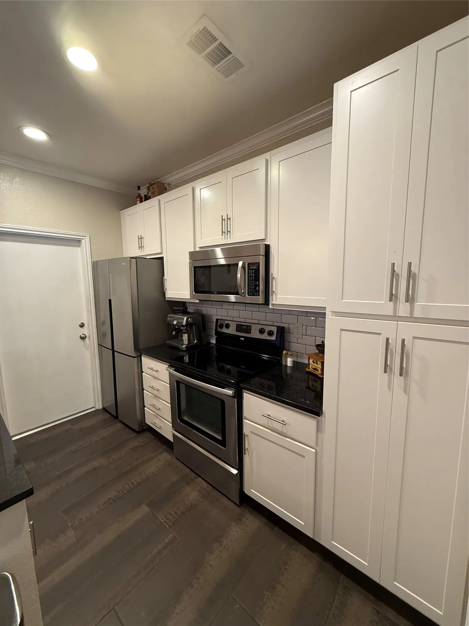 Another view of the kitchen shows the stainless steel appliances and built in microwae.
