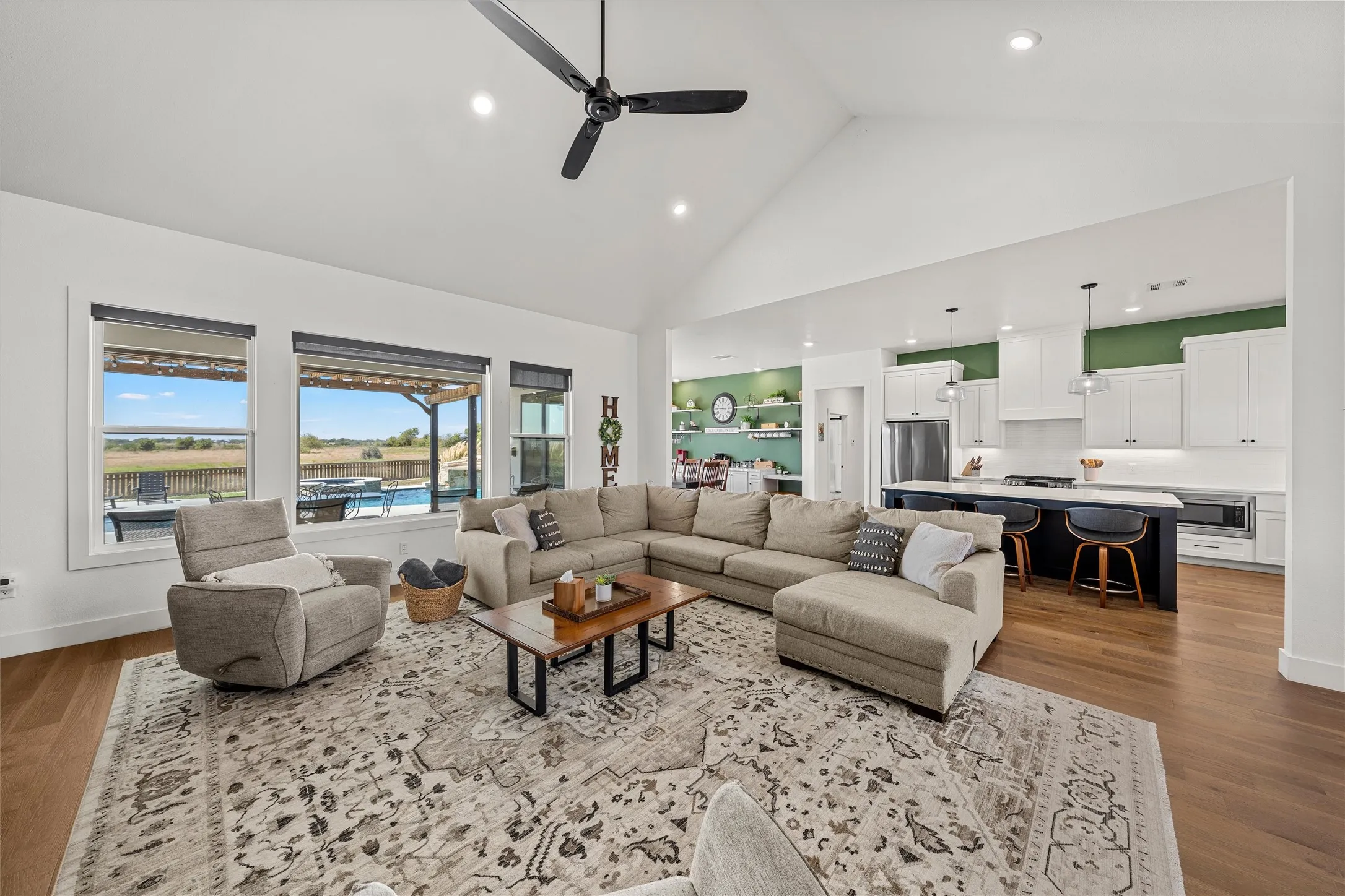Living room with vaulted ceiling, wood-finish flooring, and recessed lighting