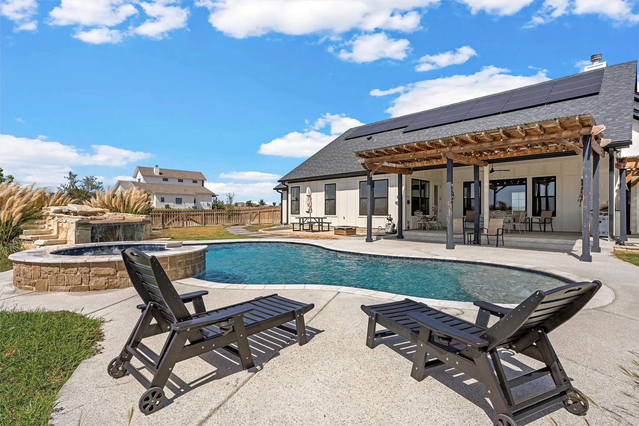 Outdoor swimming pool with integrated spa and stone surround