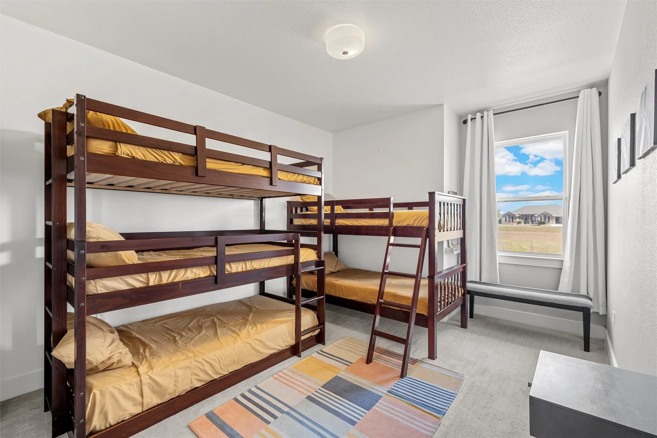 White walls, recessed window, trim molding, flush mount lighting, and gray carpeting (Bunk Room)