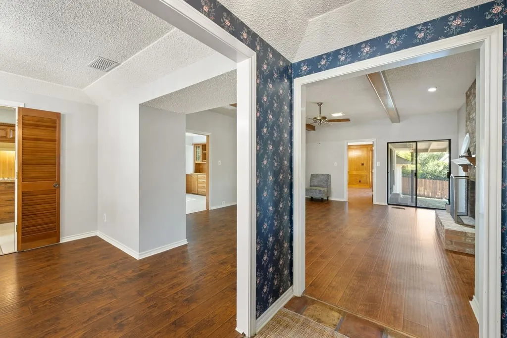Wood-finish flooring throughout, with a wood louvered sliding door, and a brick fireplace