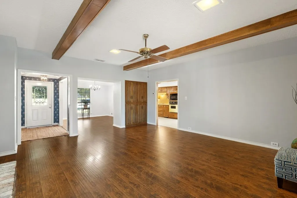 Wood-finish flooring throughout, with exposed ceiling beams, and a decorative ceiling fan