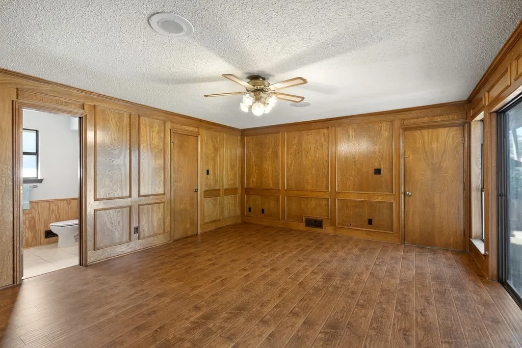 Wood-finish flooring with wood paneling, recessed lighting, and a ceiling fan