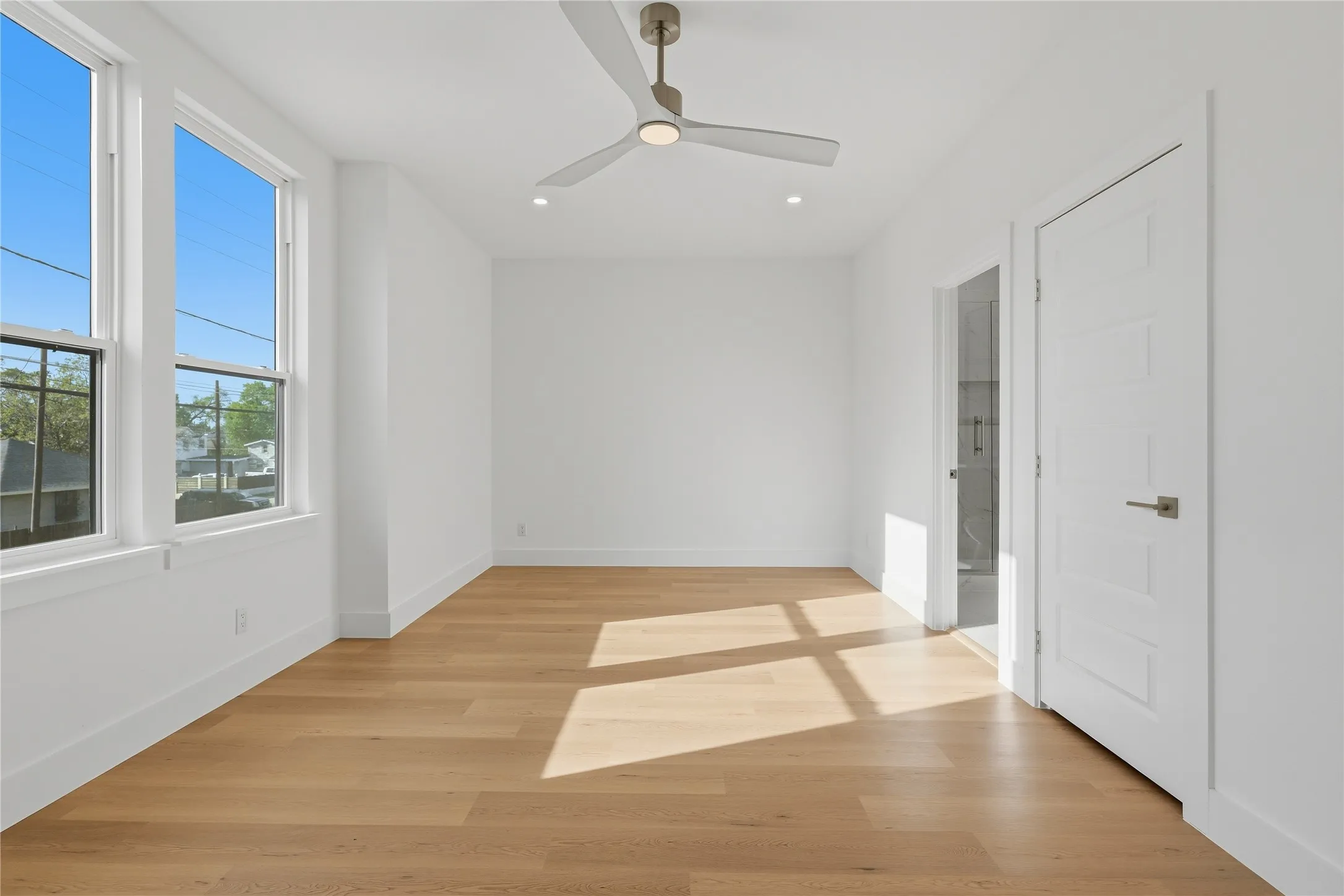 Recessed lighting, wood-finish flooring, and a modern ceiling fan