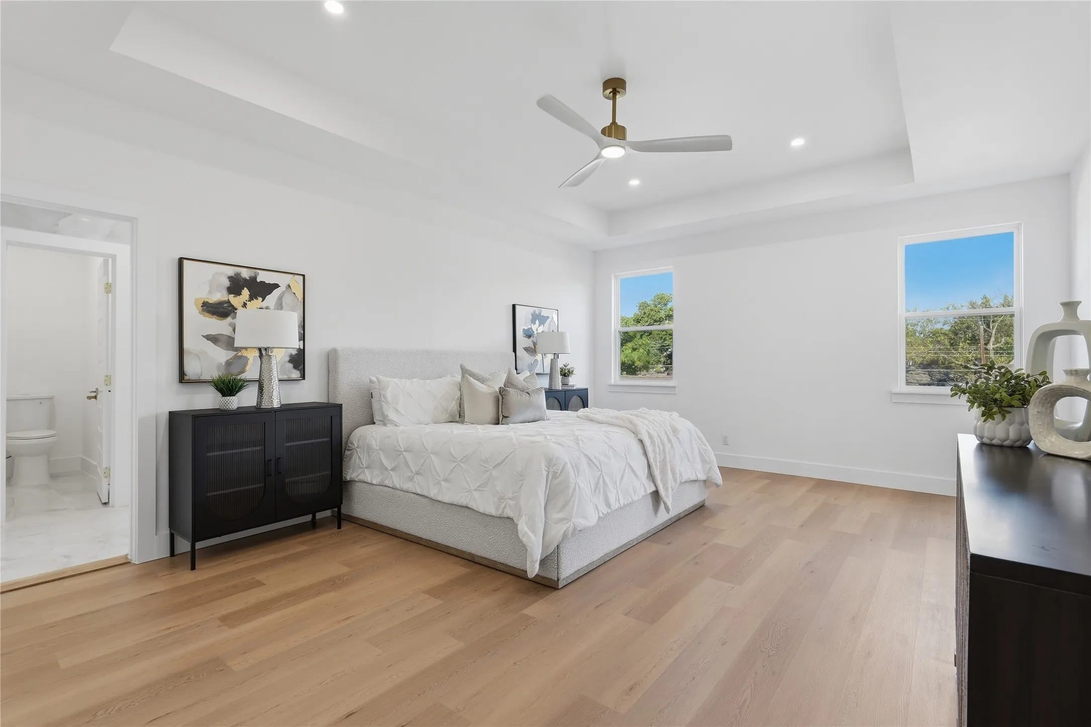 Tray ceiling with recessed lighting, wood-finish flooring, and a ceiling fan