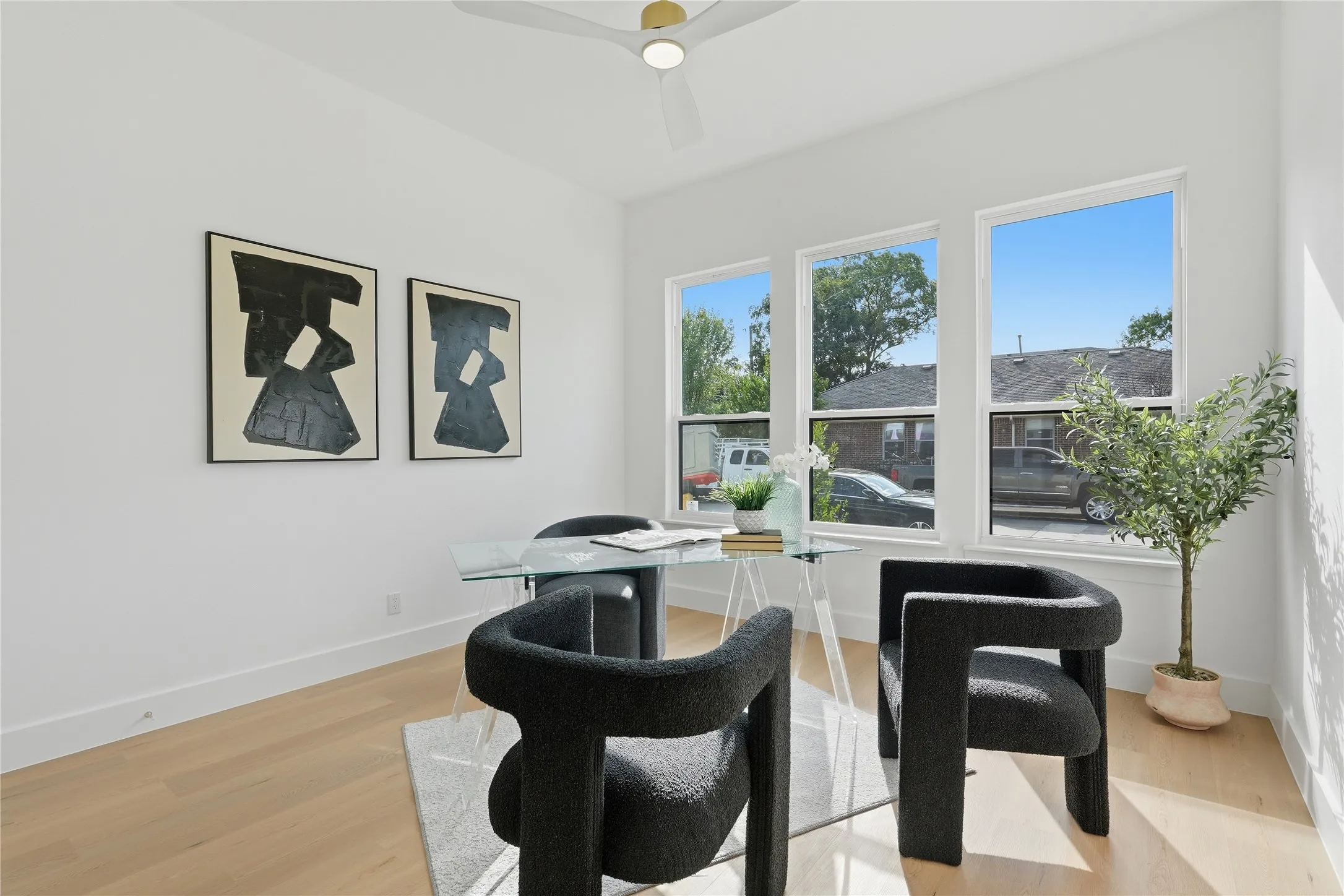 Recessed lighting, wood-finish flooring, and multiple windows providing ambient light