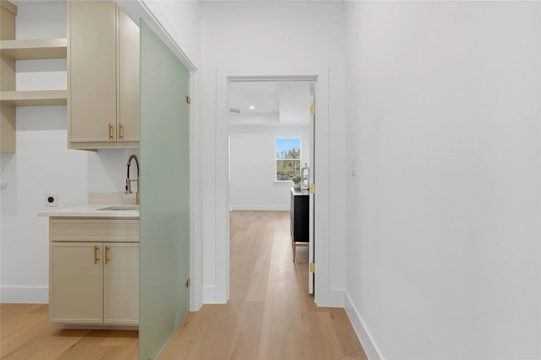 Built-in cabinetry with gold-toned hardware, white countertop, and gold-toned faucet