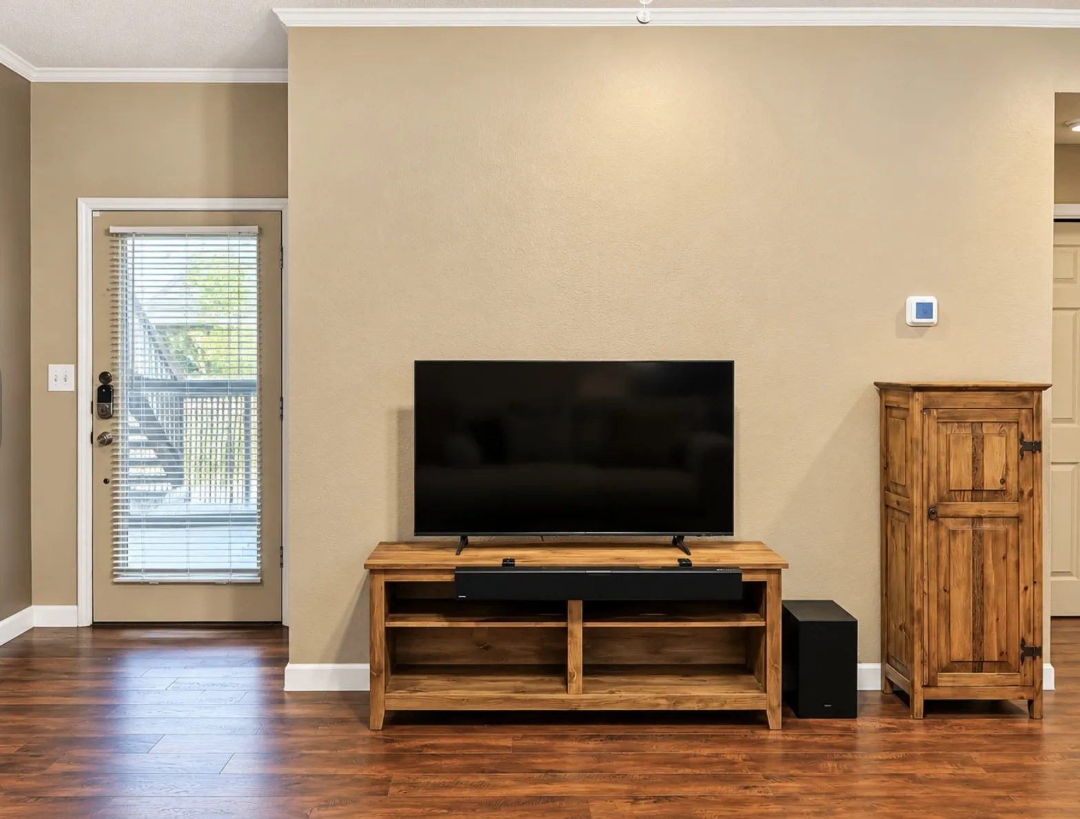 Hardwood-style flooring throughout with white crown molding and baseboards