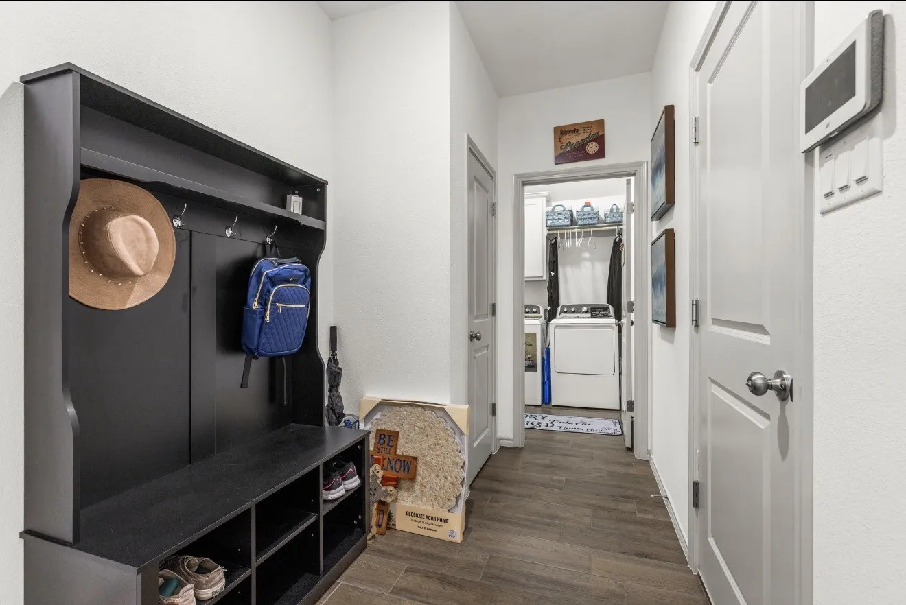 Entryway featuring wood-finish flooring, a built-in hall tree with storage, and panel doors