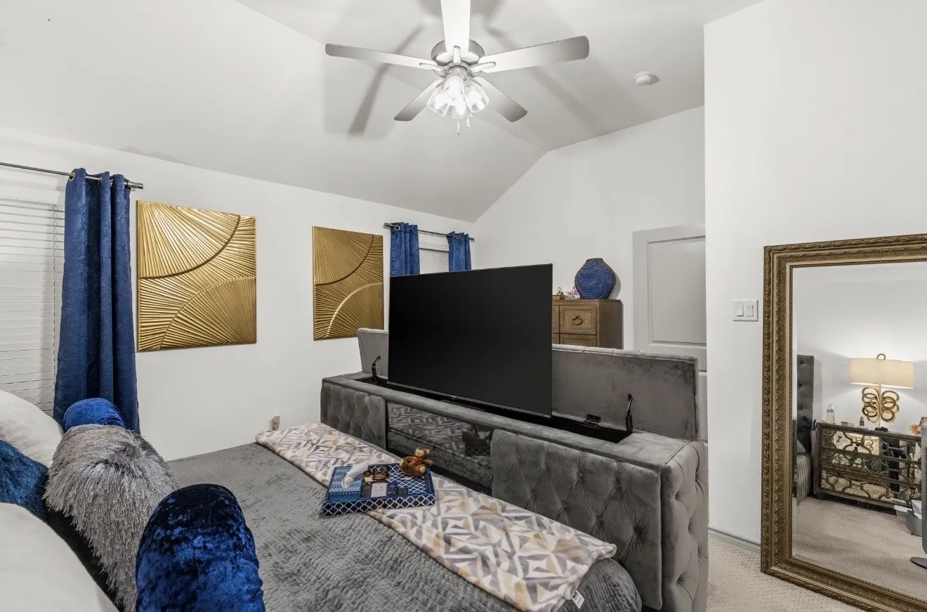 Vaulted ceiling with a ceiling fan, carpet flooring, window with blinds, and built-in media console