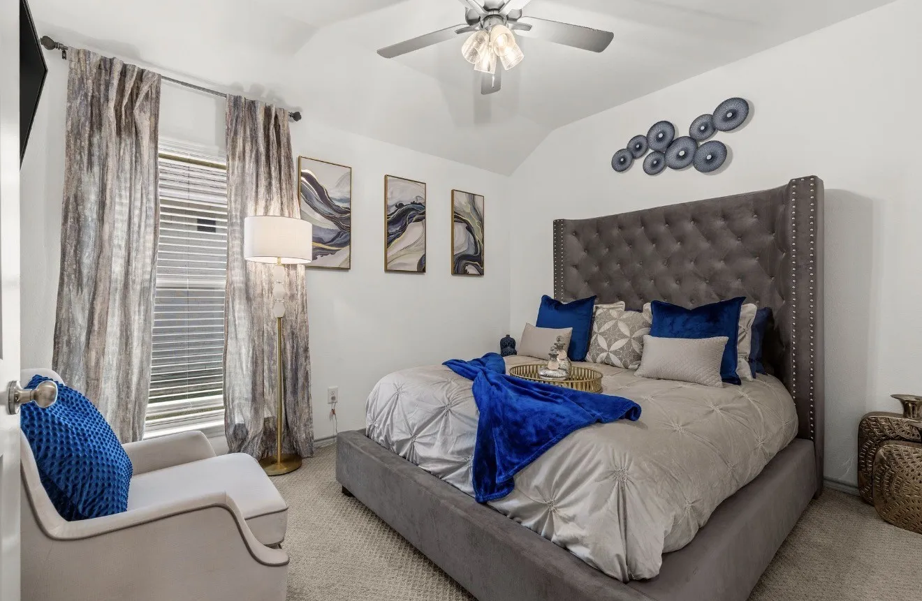 Vaulted ceiling, carpeted flooring, window with blinds, ceiling fan with light fixture, and a built-in upholstered headboard