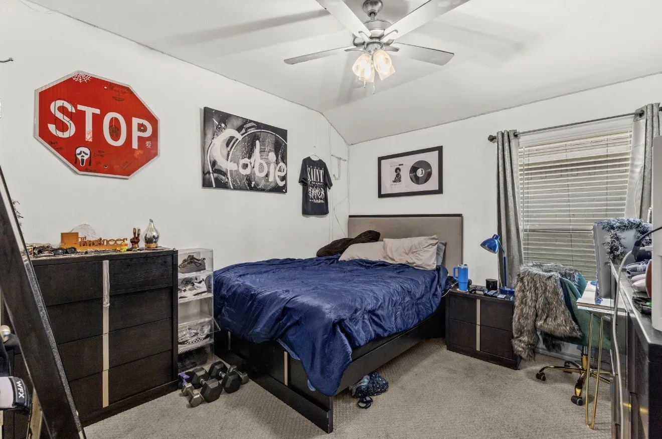 Recessed window with blinds, ceiling fan with integrated lighting, and neutral carpeting