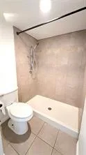 Walk-in shower with tiled walls and a white shower pan
