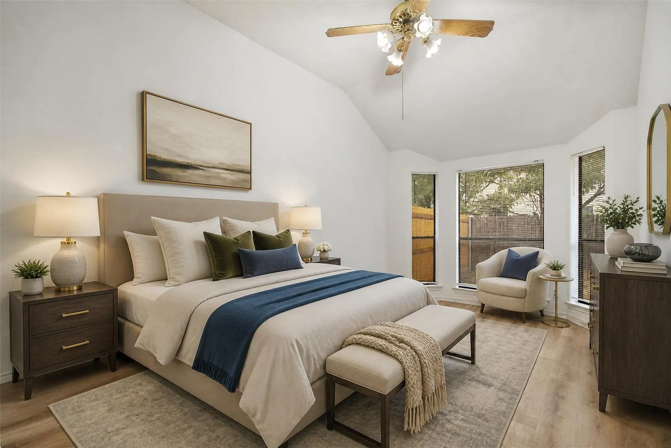 Vaulted ceiling, wood-finish flooring, ceiling fan, multiple windows, and a built-in upholstered headboard