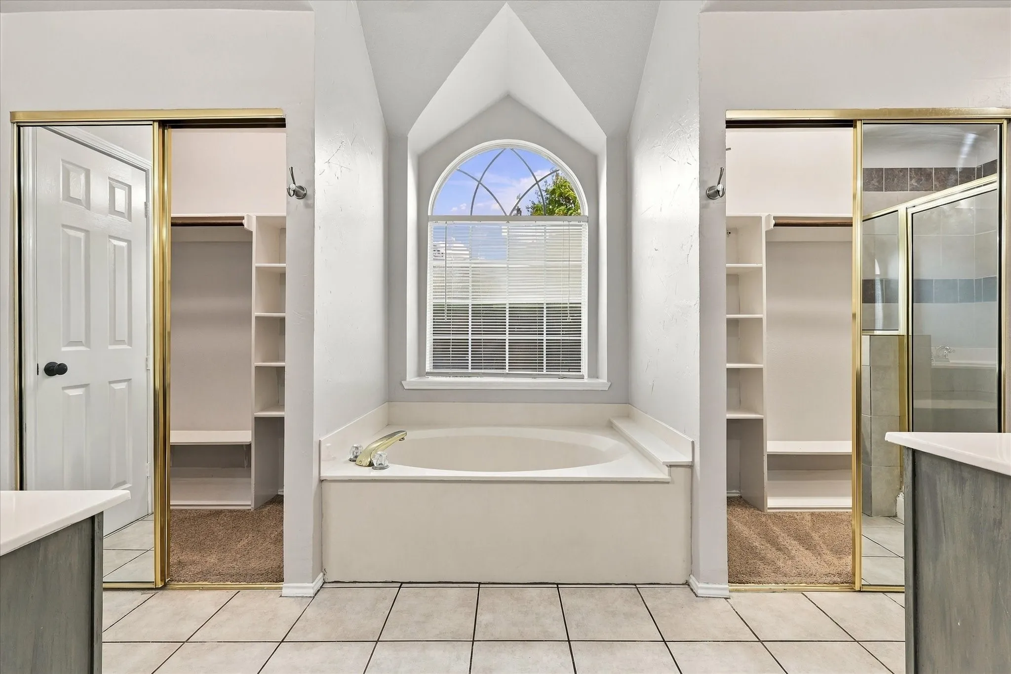 the primary bath offers separate vanities, a garden tub and separate shower.