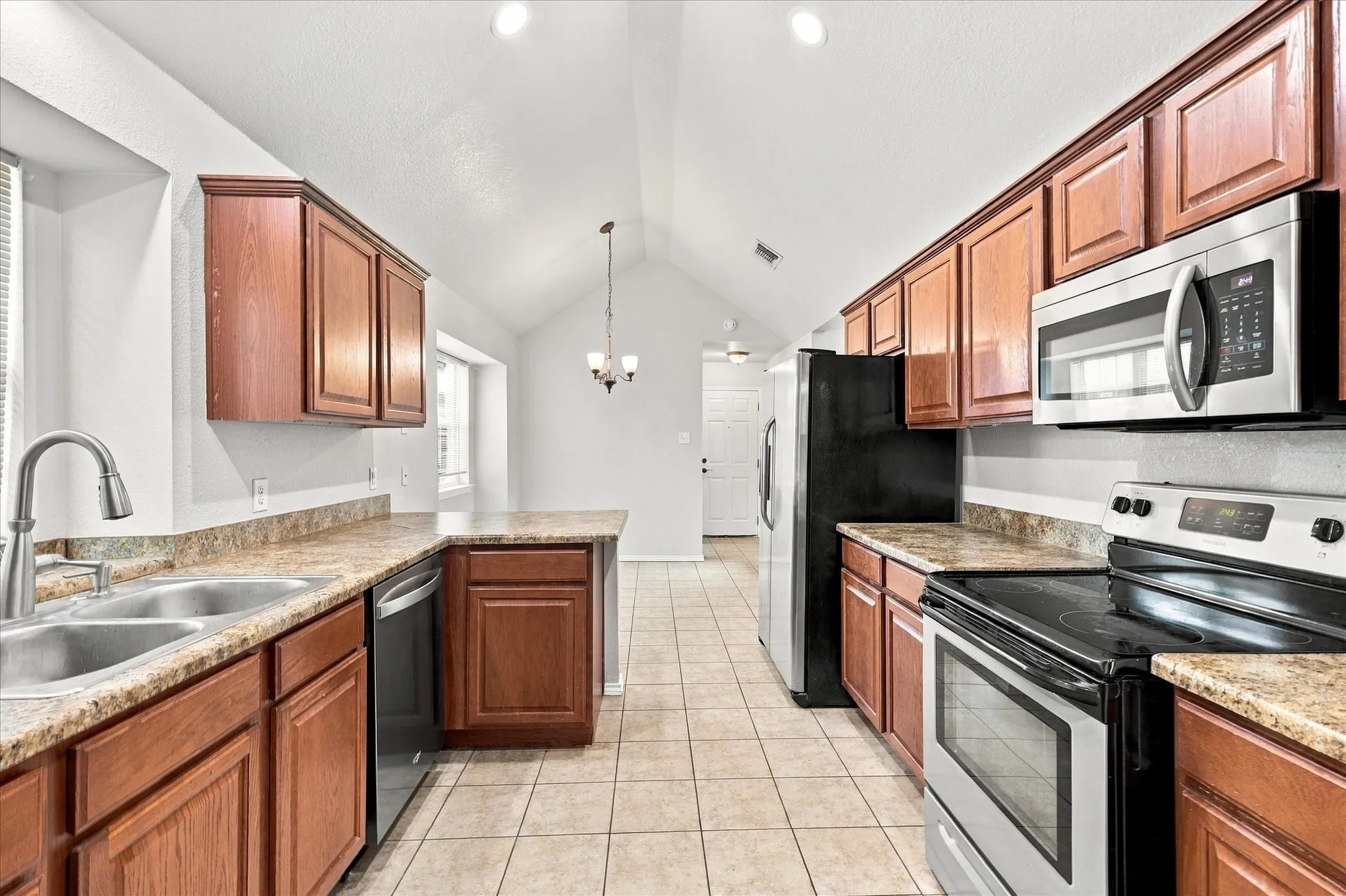 The oversized kitchen offers abundant counter and cabinet space, breakfast bar, electric range, built-in microwave and a sink positioned beneath a window overlooking the side yard. The adjoining breakfast nook features vaulted ceilings, recessed lighting and a built-in window seat.