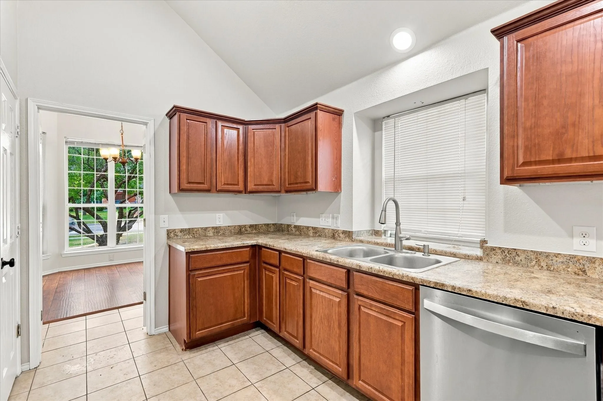 The oversized kitchen offers abundant counter and cabinet space, breakfast bar, electric range, built-in microwave and a sink positioned beneath a window overlooking the side yard. The adjoining breakfast nook features vaulted ceilings, recessed lighting and a built-in window seat.