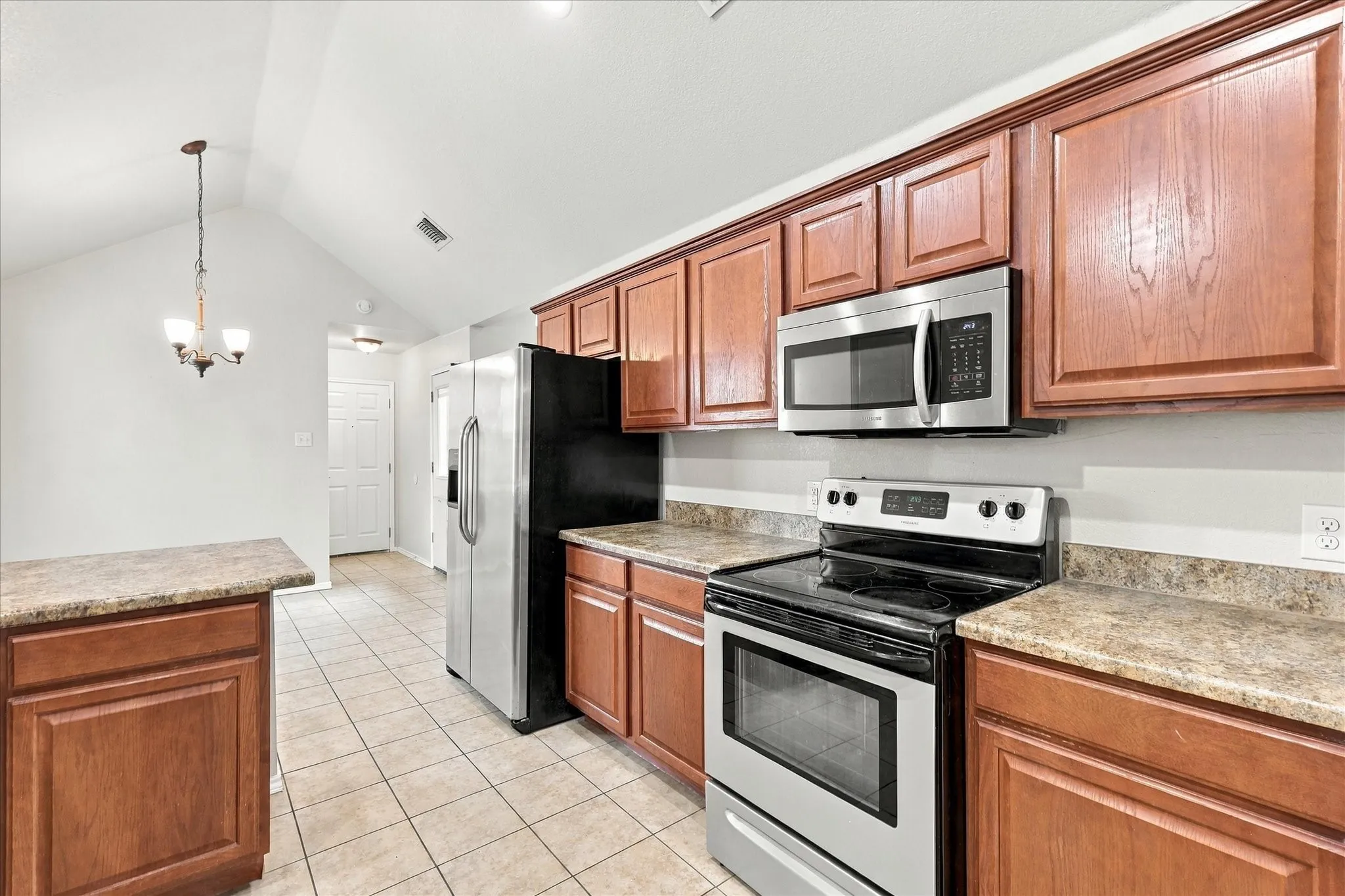 The oversized kitchen offers abundant counter and cabinet space, breakfast bar, electric range, built-in microwave and a sink positioned beneath a window overlooking the side yard. The adjoining breakfast nook features vaulted ceilings, recessed lighting and a built-in window seat.