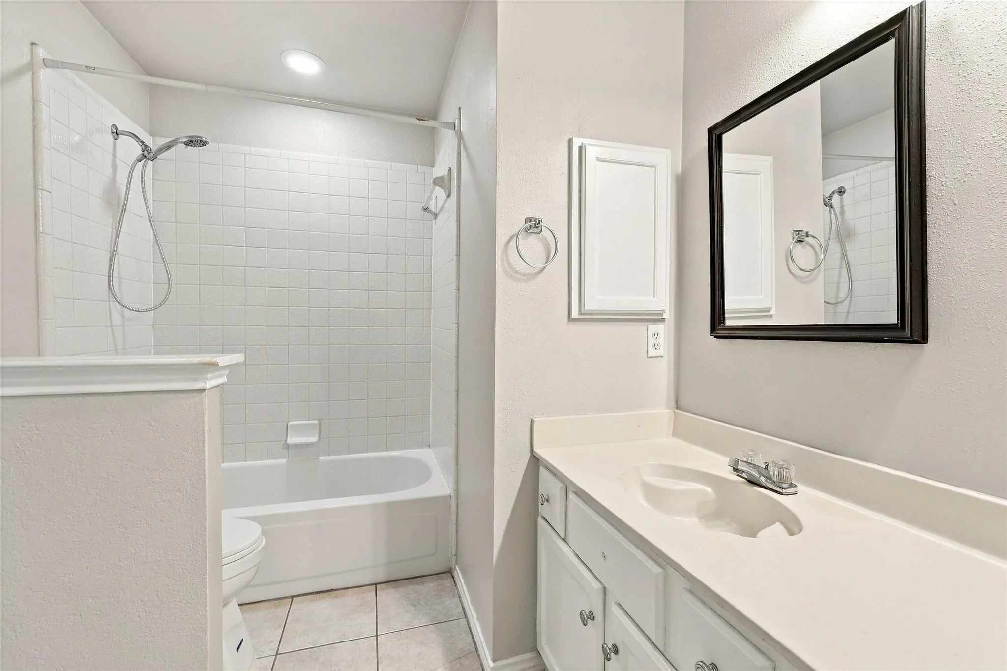 Hall bathroom featuring dual sinks, ample counter space and tub/shower combo.