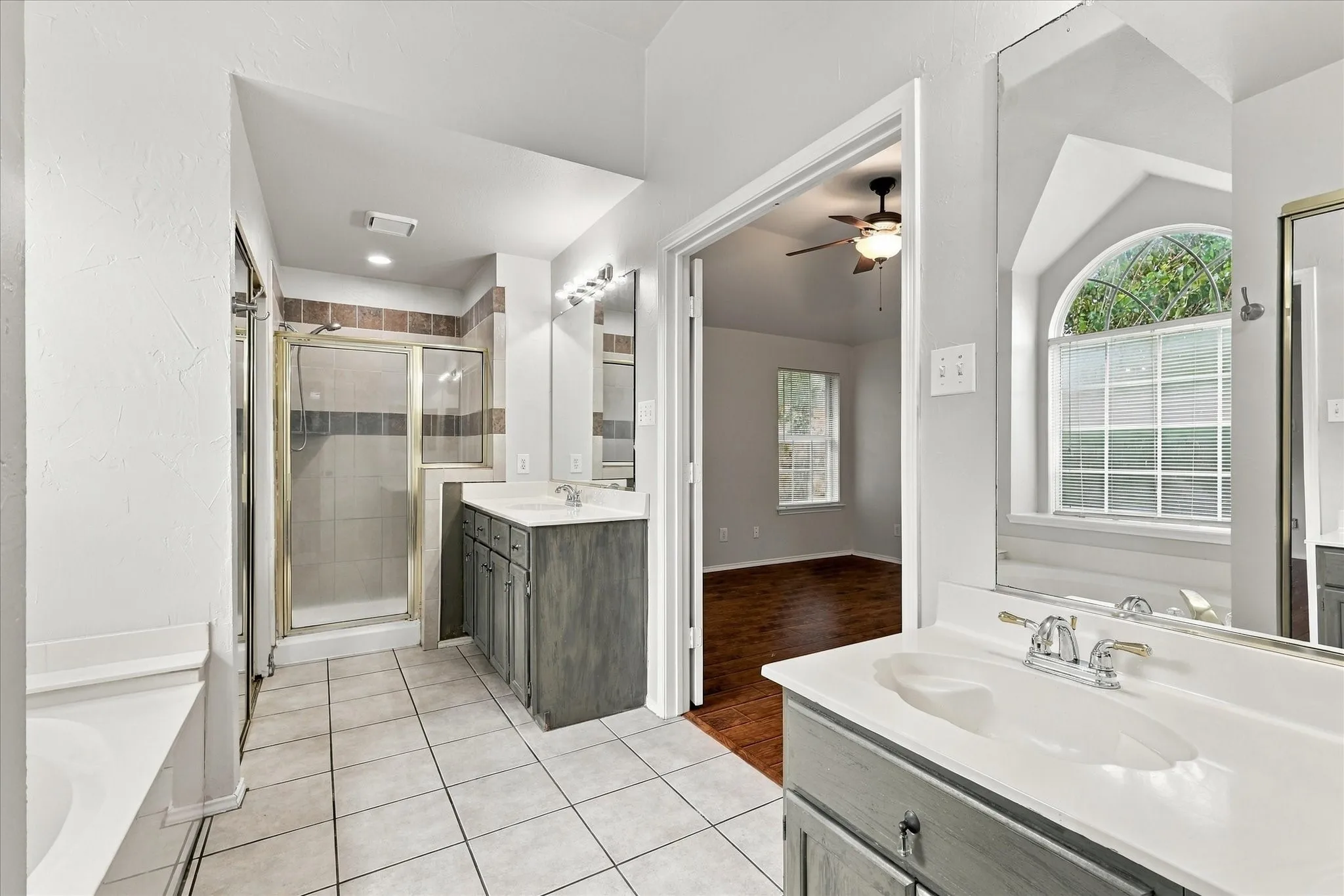 the primary bath offers separate vanities, a garden tub and separate shower.