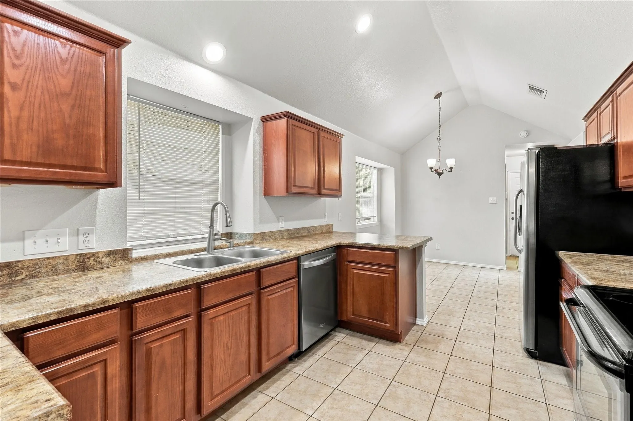 The oversized kitchen offers abundant counter and cabinet space, breakfast bar, electric range, built-in microwave and a sink positioned beneath a window overlooking the side yard. The adjoining breakfast nook features vaulted ceilings, recessed lighting and a built-in window seat.