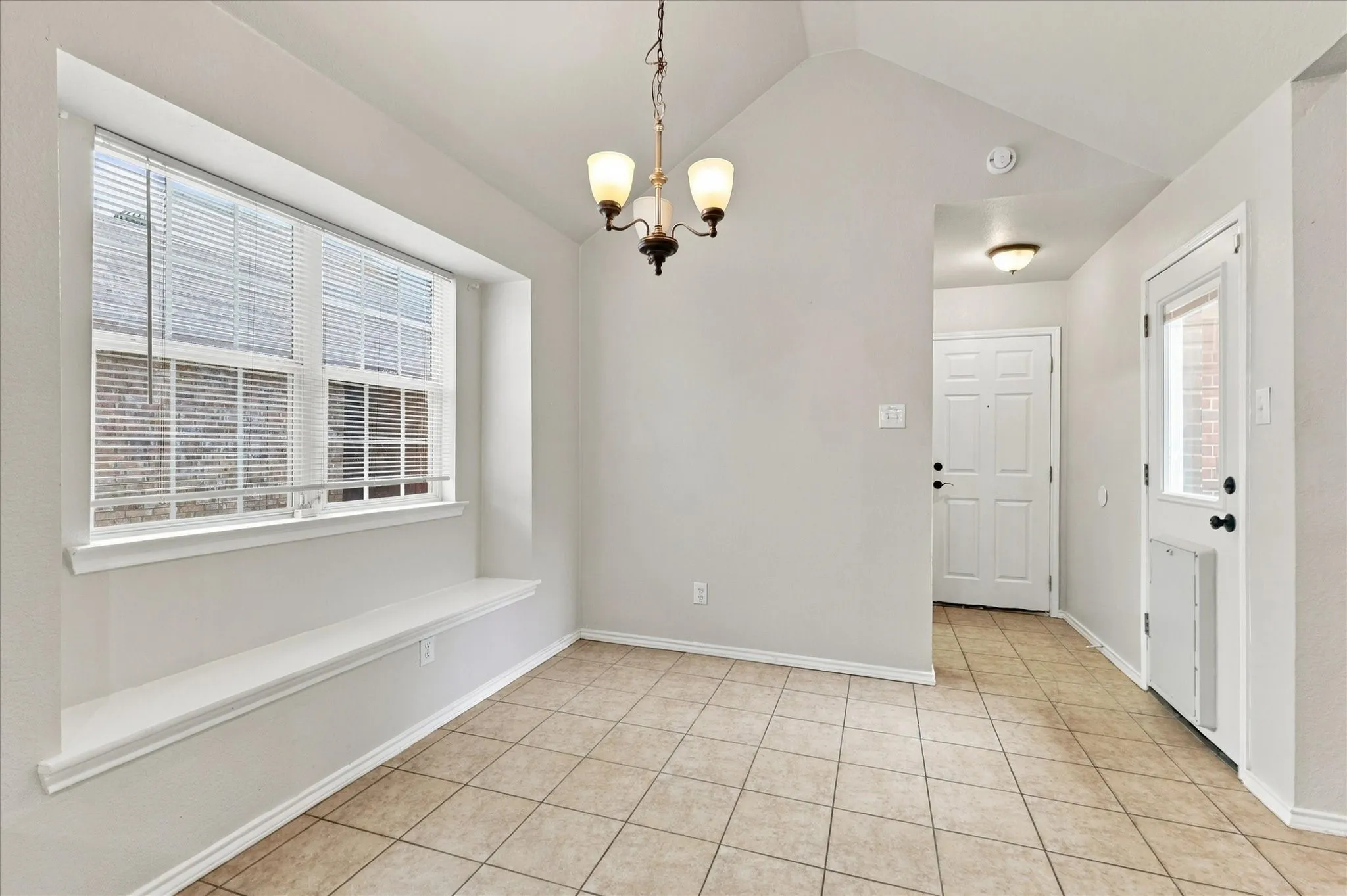 The oversized kitchen offers abundant counter and cabinet space, breakfast bar, electric range, built-in microwave and a sink positioned beneath a window overlooking the side yard. The adjoining breakfast nook features vaulted ceilings, recessed lighting and a built-in window seat.