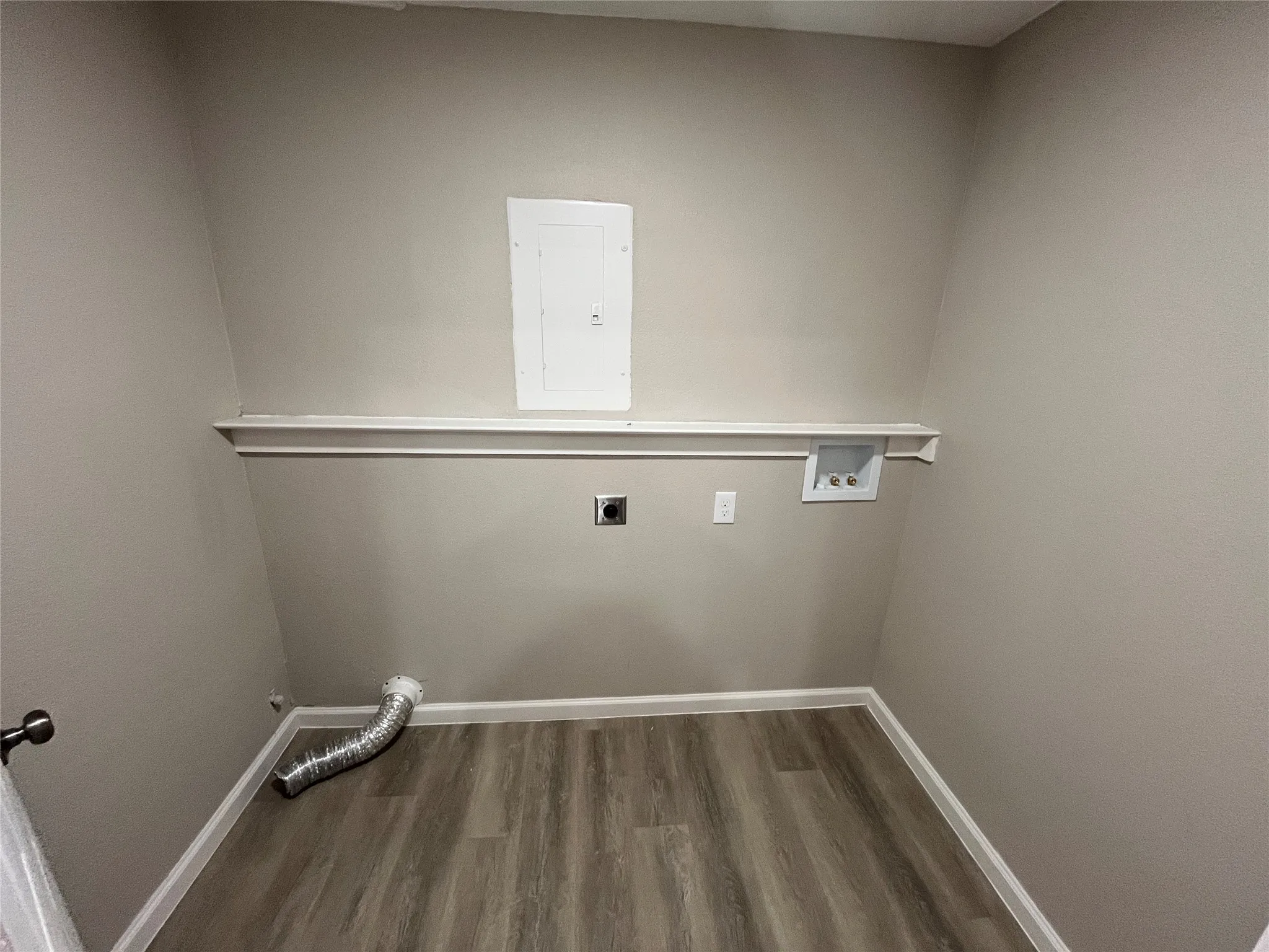 Wood-finish flooring, white wall trim, and a utility shelf