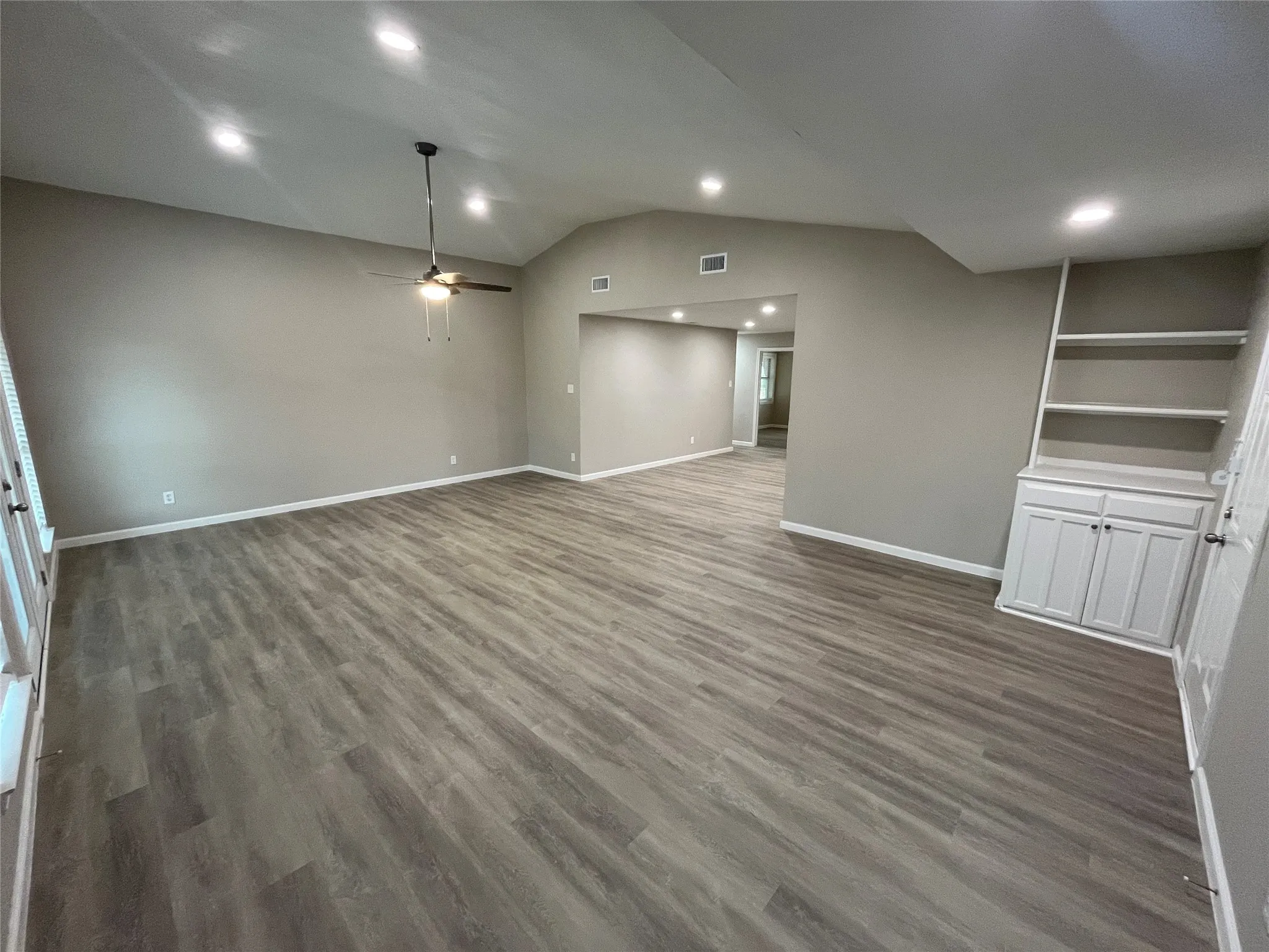 Vaulted ceiling with recessed lighting and a ceiling fan