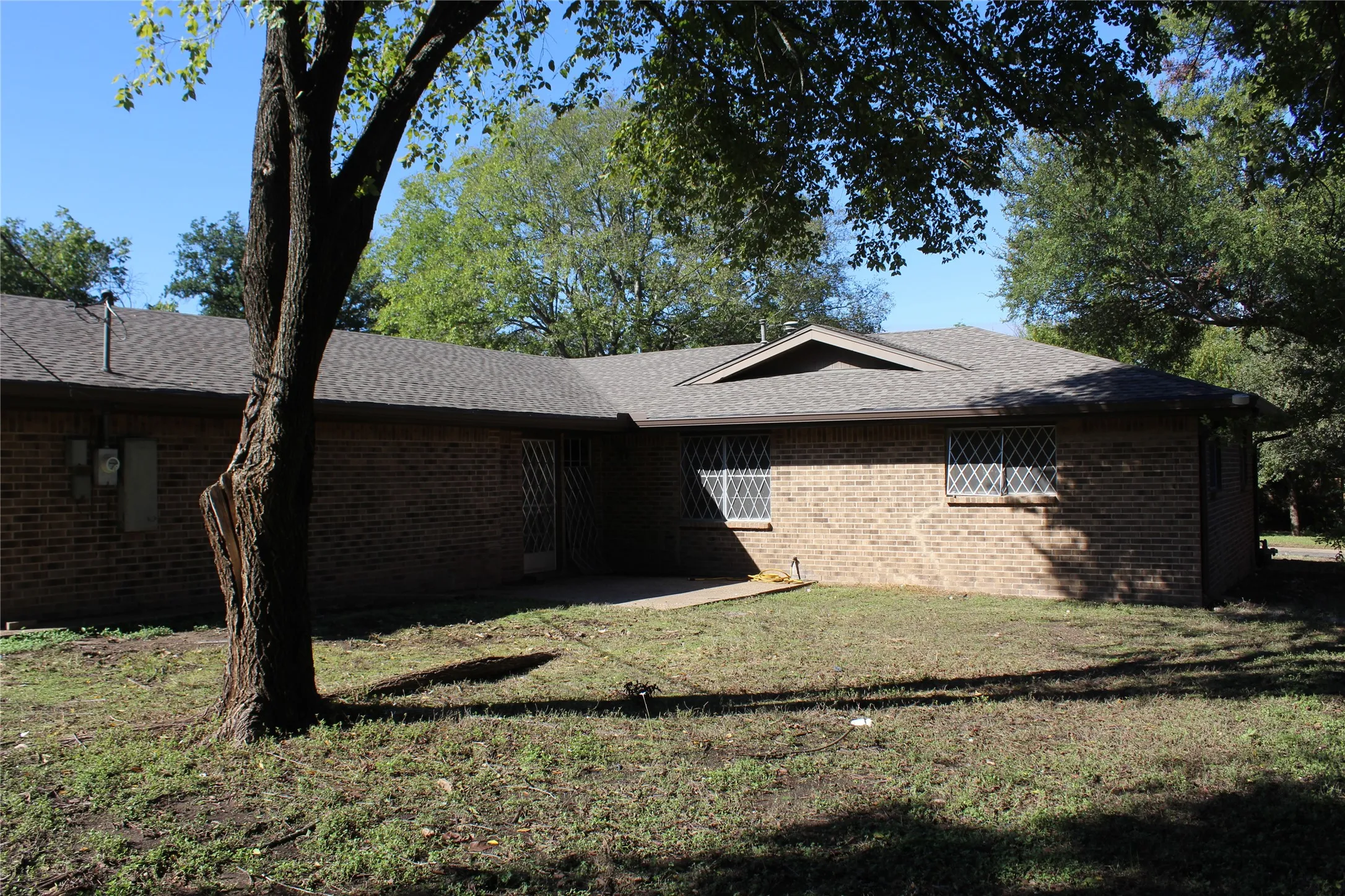 Brick exterior with a gabled roofline and lattice window coverings