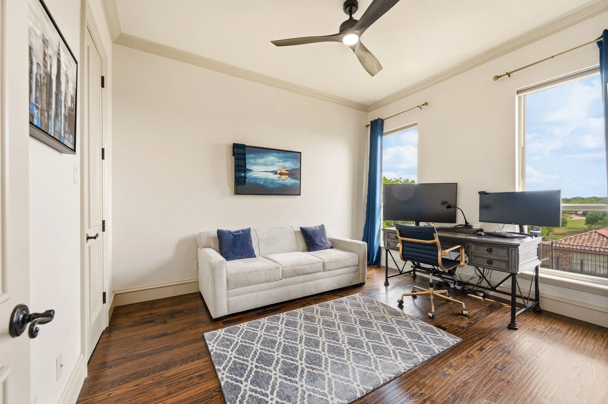 Hardwood-finish flooring, high ceilings with crown molding, and a ceiling fan
