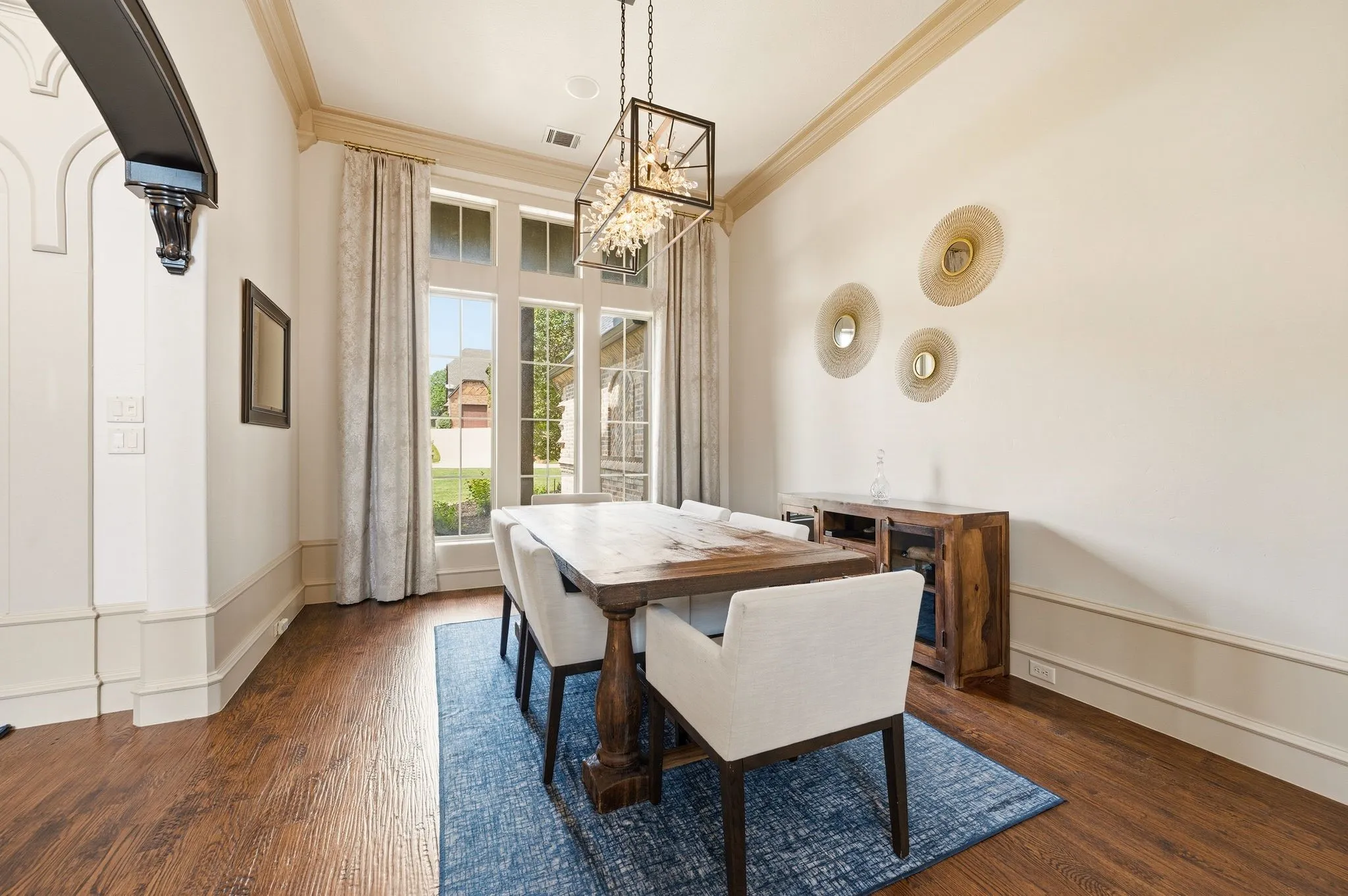 Hardwood flooring, crown molding, large picture windows, and a built-in light fixture