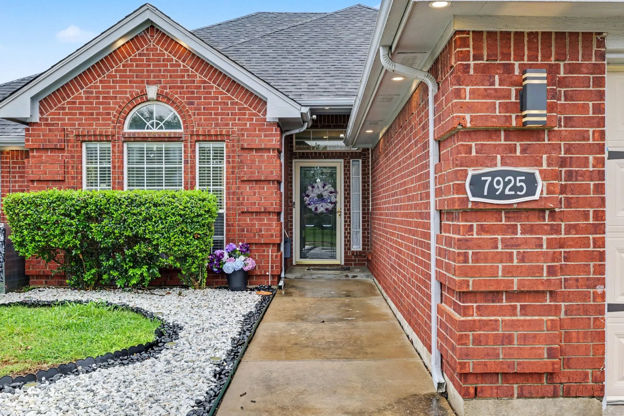 Red brick exterior with white trim, arched window, and recessed lighting