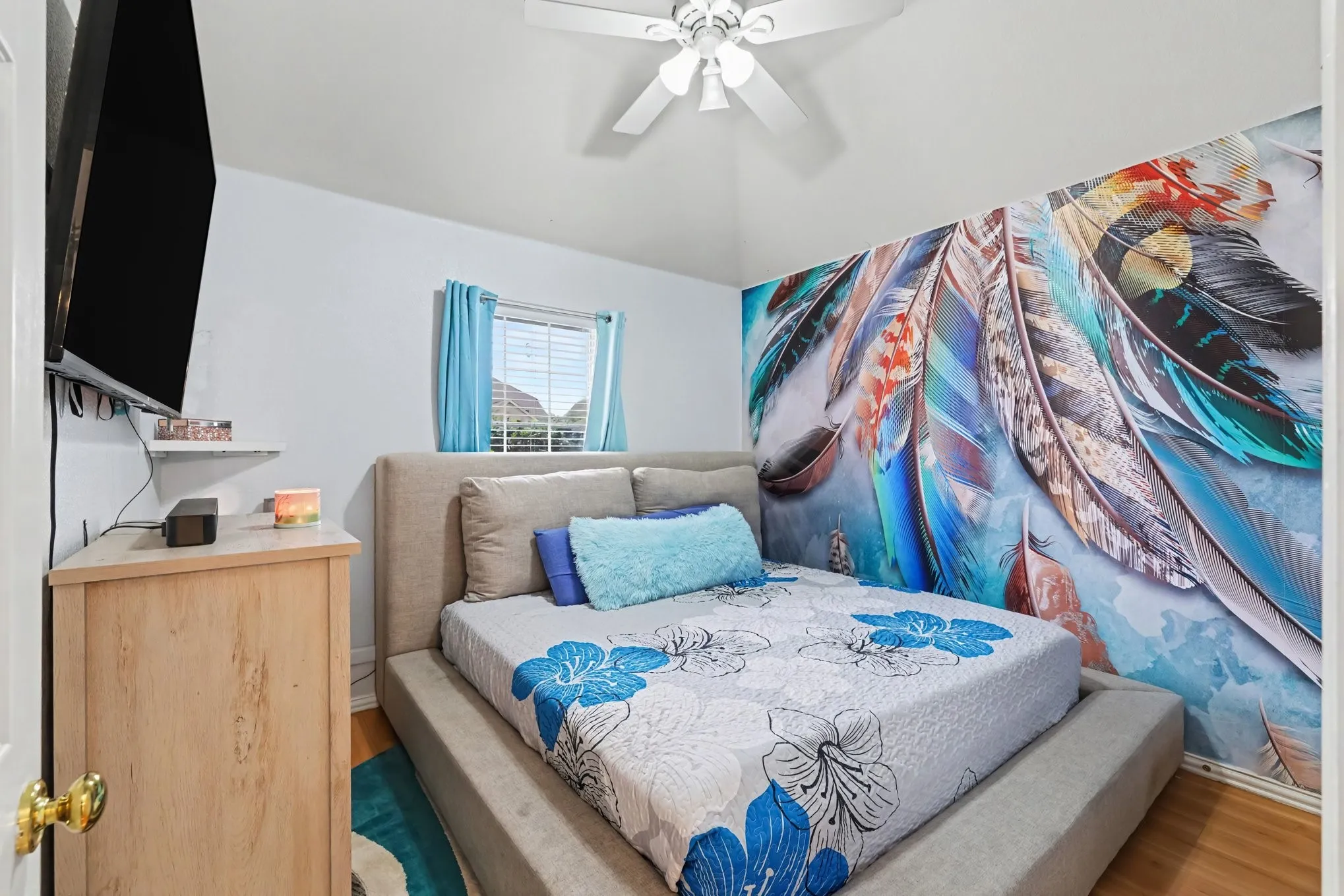 Sloped ceiling with a white ceiling fan, wood-finish flooring, and a window with blinds