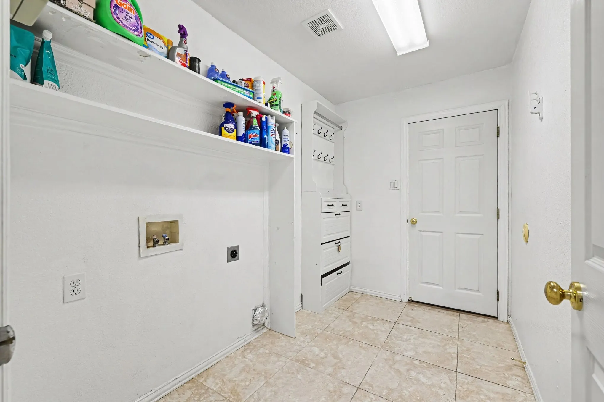 Utility area featuring built-in shelving, tile flooring, and a recessed ceiling light