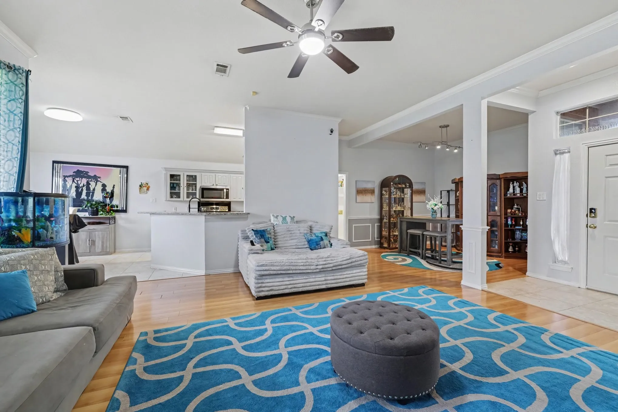 Open-concept living area with wood-finish flooring, a ceiling fan, and recessed lighting