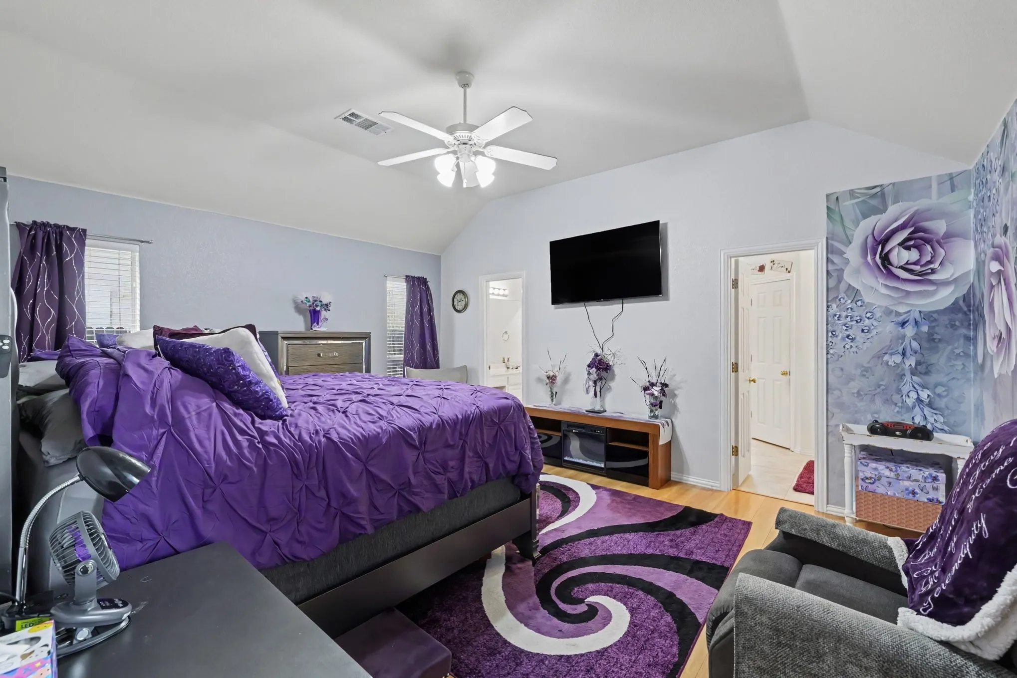 Vaulted ceiling, ceiling fan, wood-finish flooring, accent wall, transom window