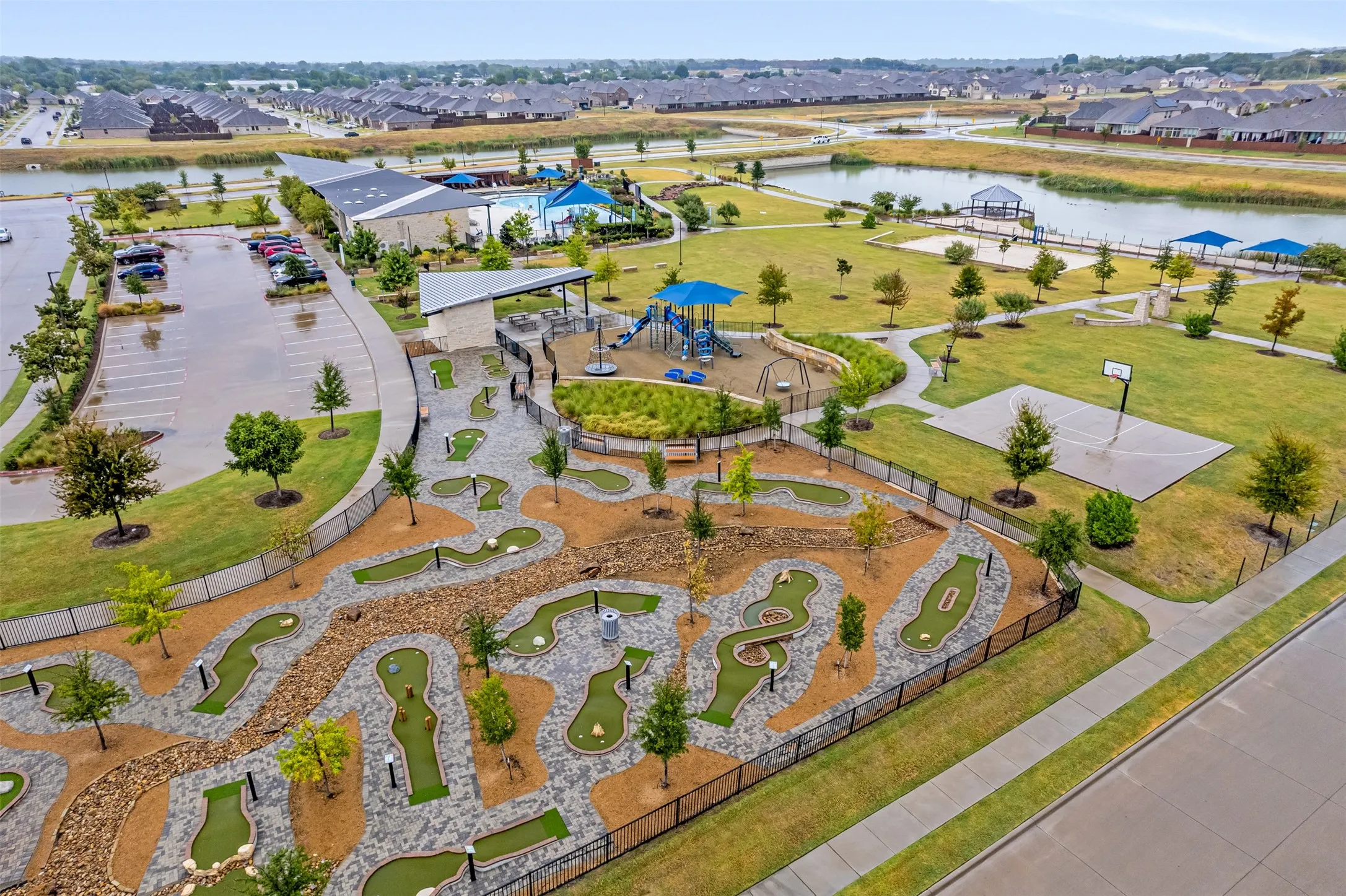 Community amenities featuring a miniature golf course, playground, half-basketball court, and a park area with a water feature