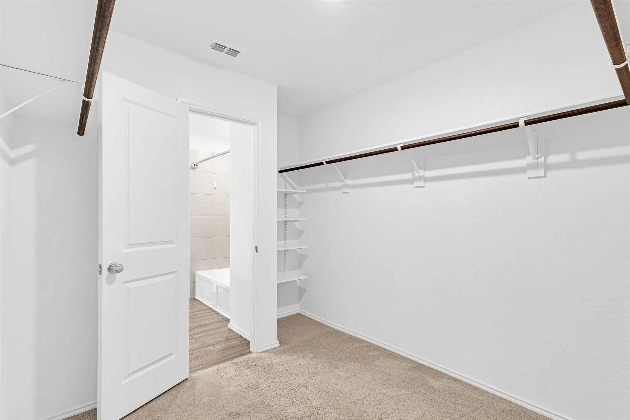 Carpeted flooring with white walls and built-in shelving