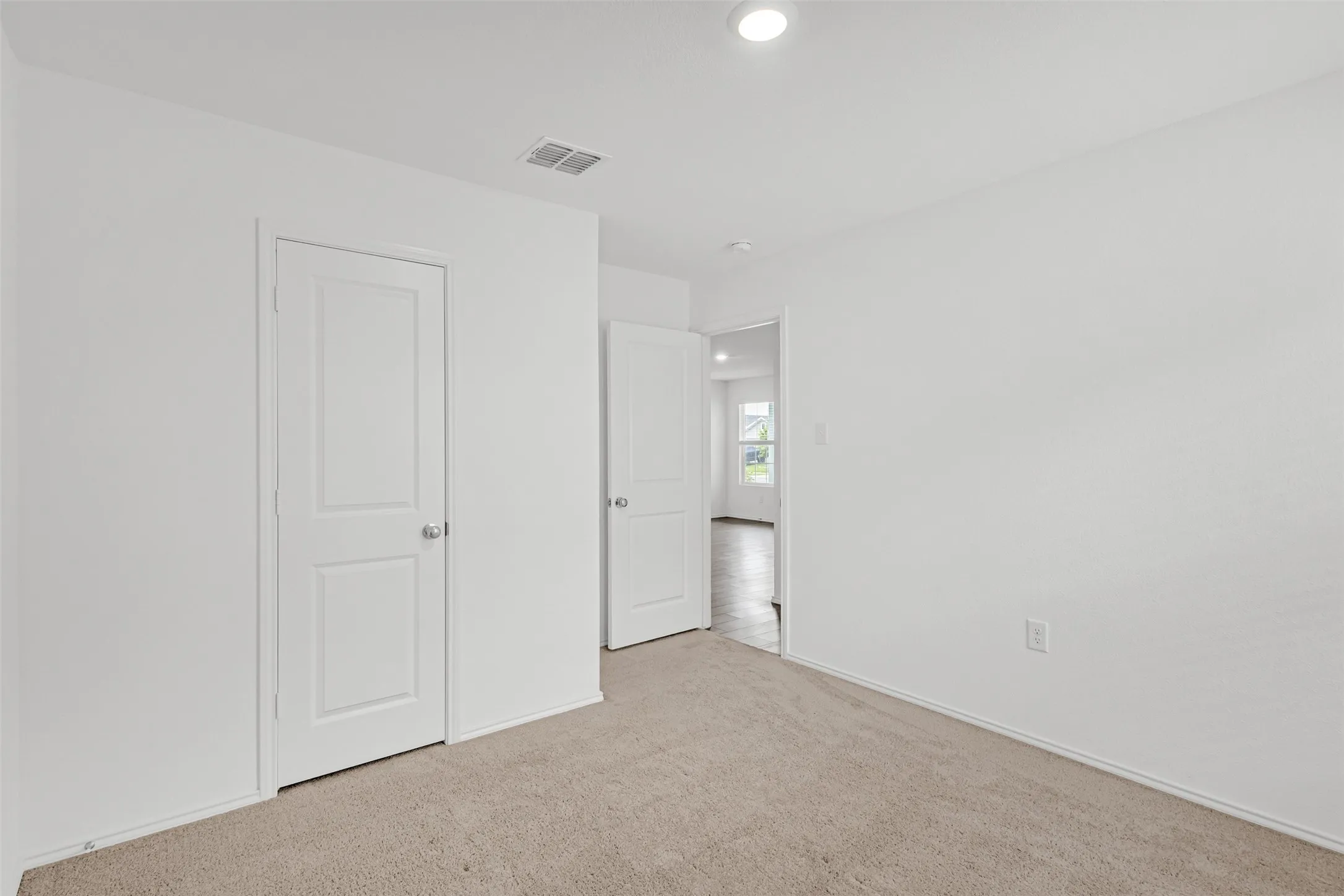 Plush carpeting, recessed lighting, white interior doors, and crisp white walls